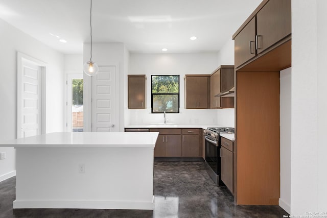 kitchen featuring light countertops, pendant lighting, stainless steel range with gas stovetop, and concrete floors