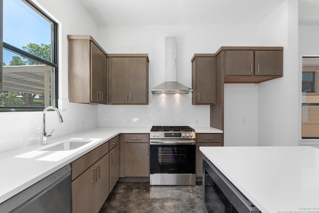 kitchen with a sink, wall chimney exhaust hood, stainless steel appliances, and light countertops