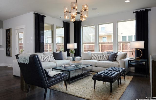 living room featuring a notable chandelier, plenty of natural light, and dark wood-type flooring