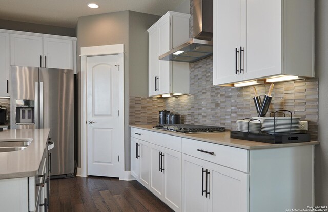 kitchen with white cabinetry, dark wood-type flooring, tasteful backsplash, and wall chimney exhaust hood