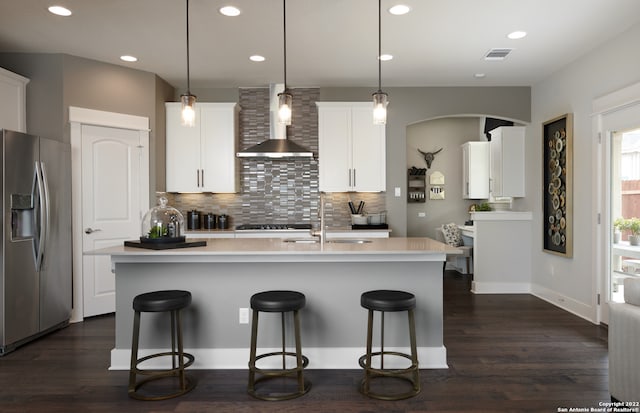 kitchen with decorative backsplash, dark hardwood / wood-style flooring, stainless steel appliances, and wall chimney exhaust hood