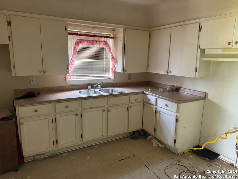 kitchen featuring white cabinetry, light tile patterned floors, and sink