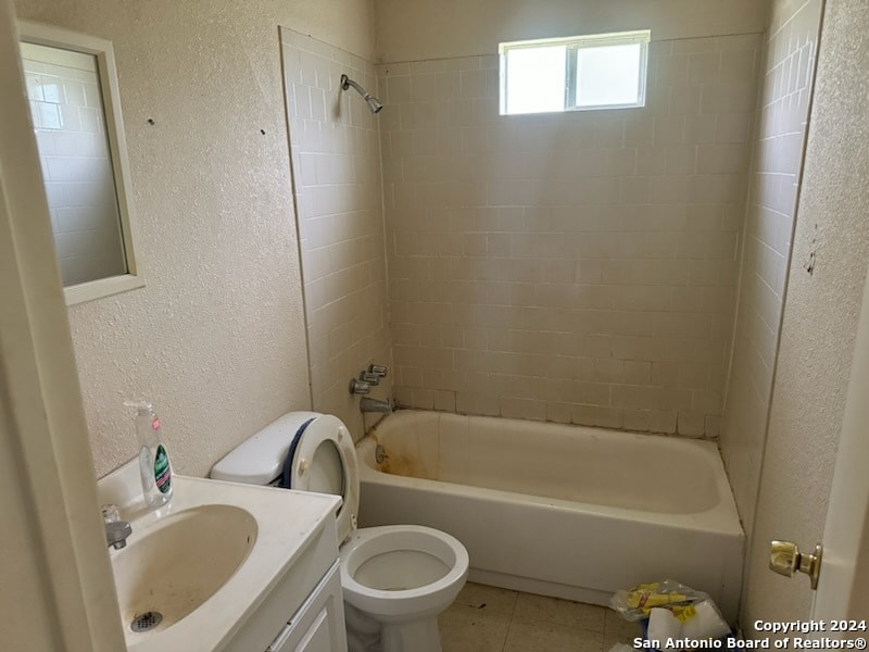 full bathroom featuring vanity, toilet, tile patterned floors, and tiled shower / bath