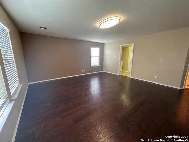 spare room with dark wood-type flooring and a textured ceiling