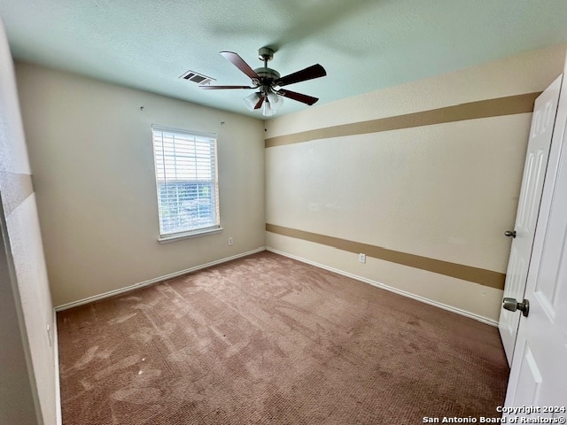 spare room featuring carpet and ceiling fan