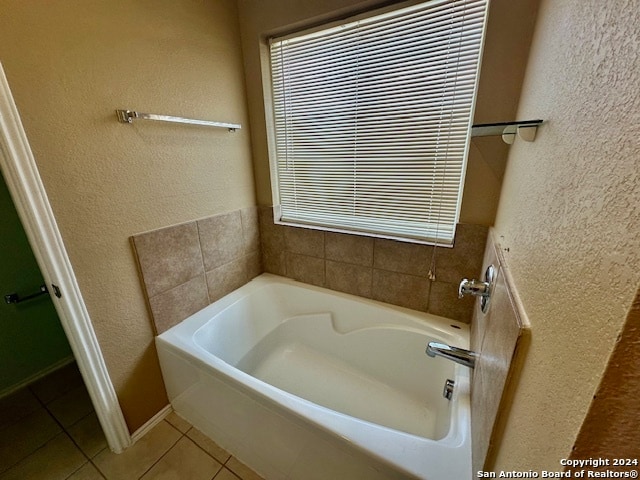 bathroom with tile patterned floors and a bath