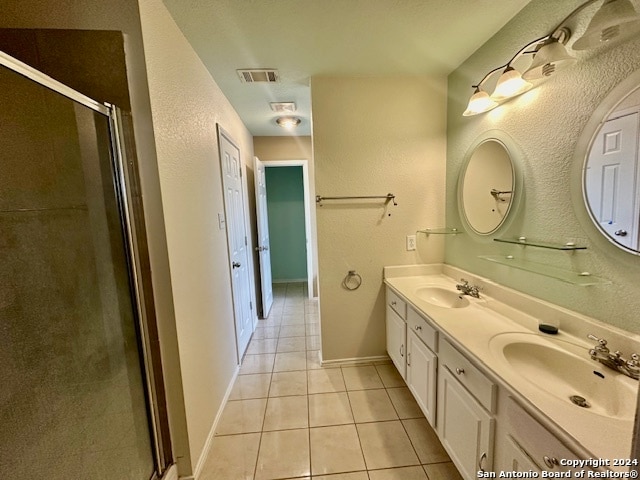 bathroom featuring double vanity, an enclosed shower, and tile patterned floors