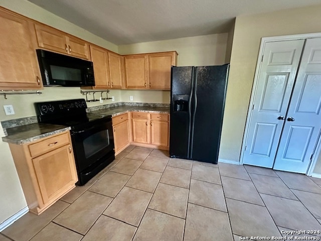 kitchen featuring black appliances, light brown cabinets, and light tile patterned floors