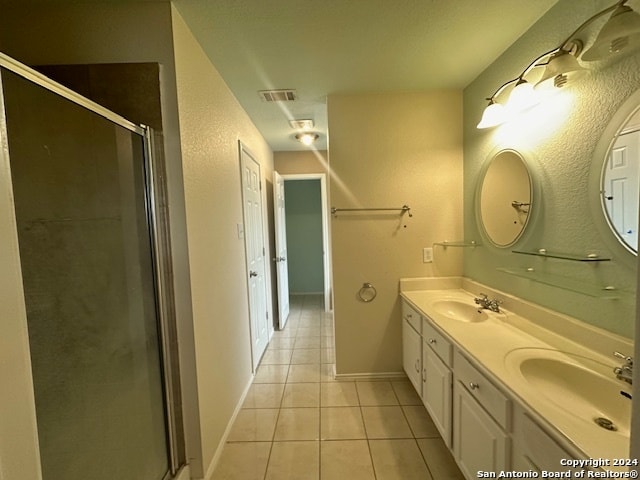 bathroom with an enclosed shower, tile patterned floors, and dual bowl vanity