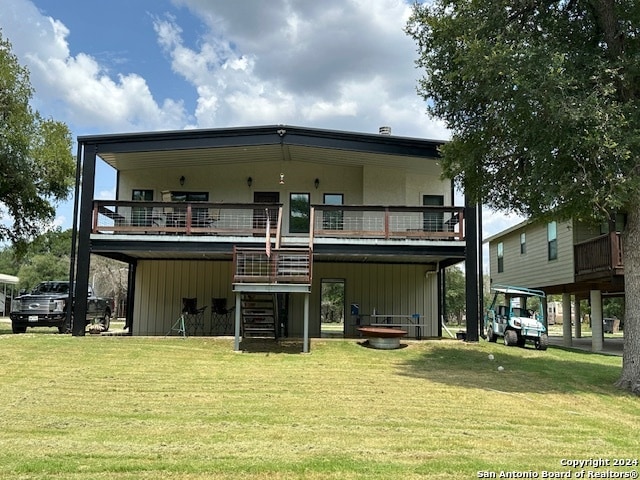 back of house with a balcony and a lawn