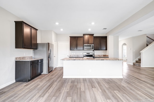 kitchen featuring a kitchen island with sink, light hardwood / wood-style flooring, and stainless steel appliances