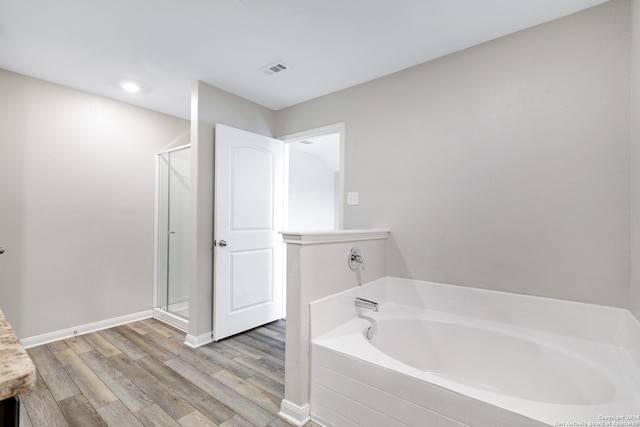 bathroom featuring separate shower and tub and wood-type flooring