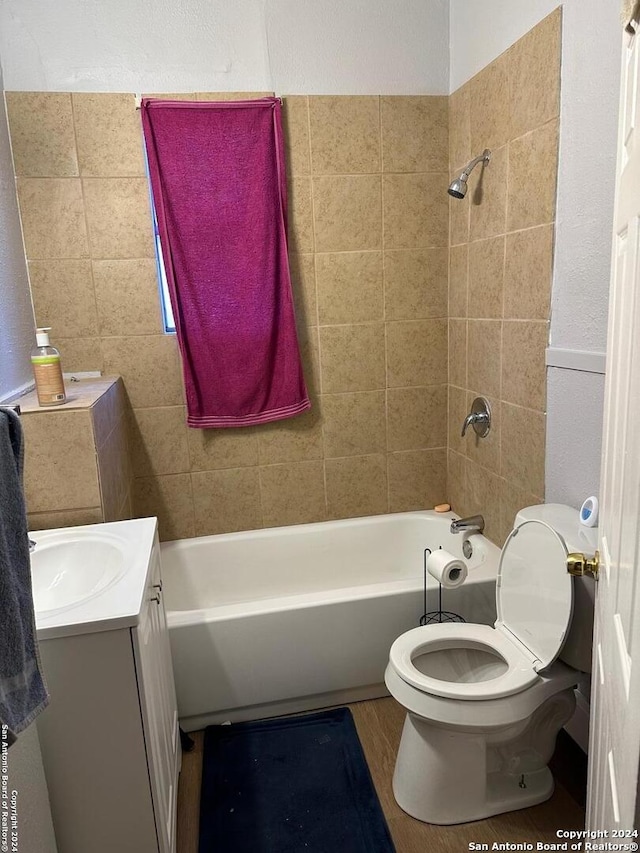 bathroom with toilet, shower / bath combination, wood finished floors, and vanity
