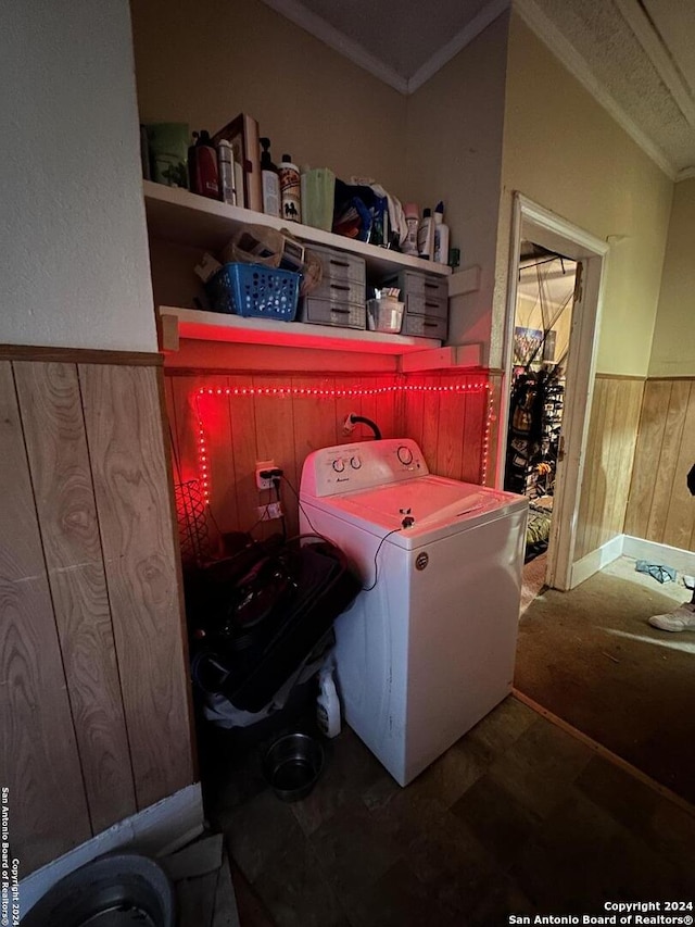 washroom featuring washer / clothes dryer, crown molding, wood walls, and wainscoting