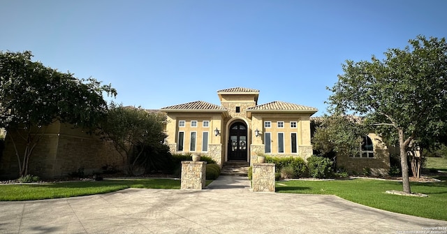 mediterranean / spanish home with a front yard