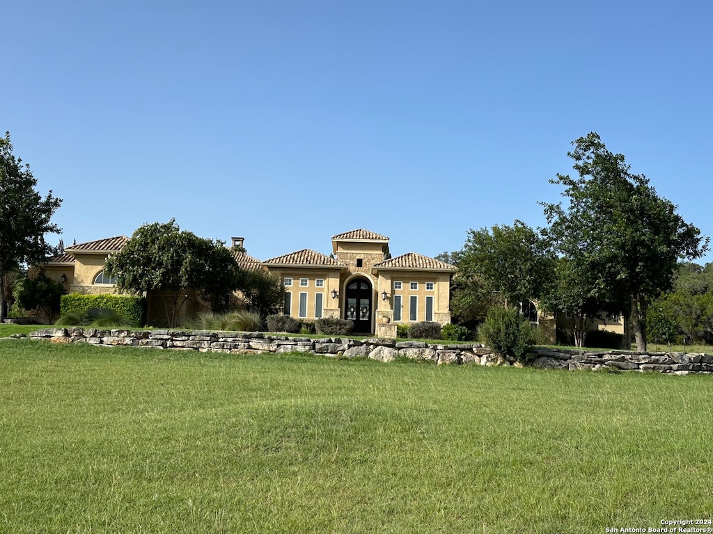 mediterranean / spanish-style home with a front lawn