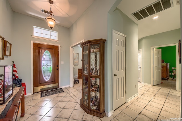 tiled foyer featuring a towering ceiling