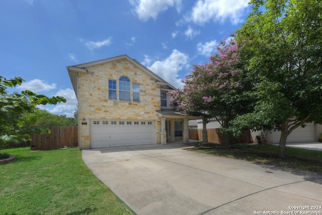 view of property featuring a garage and a front lawn