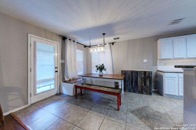 tiled dining space featuring a notable chandelier