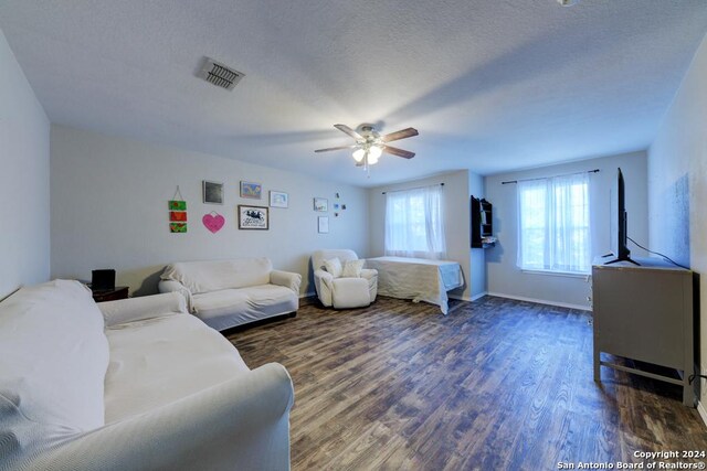 living room featuring a textured ceiling, ceiling fan, and wood-type flooring