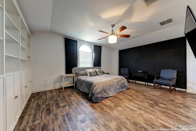 bedroom featuring dark wood-type flooring, vaulted ceiling, and ceiling fan