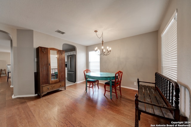 dining space featuring light hardwood / wood-style floors and an inviting chandelier