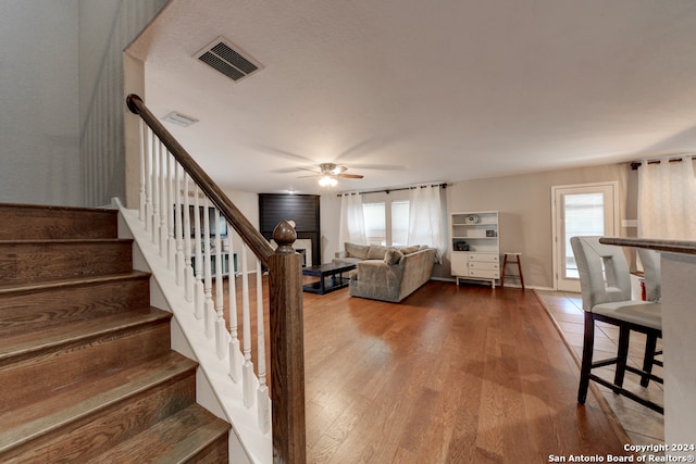 staircase featuring hardwood / wood-style floors and ceiling fan