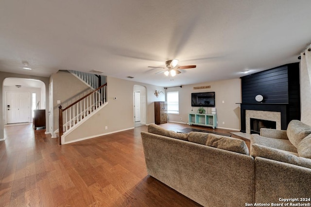 living room with hardwood / wood-style floors, a high end fireplace, and ceiling fan