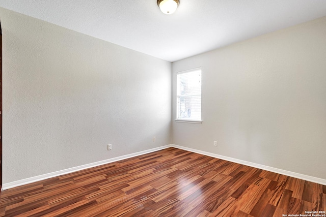 unfurnished room with dark hardwood / wood-style flooring