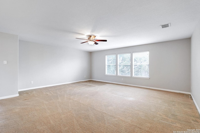 spare room with a textured ceiling, ceiling fan, and carpet flooring