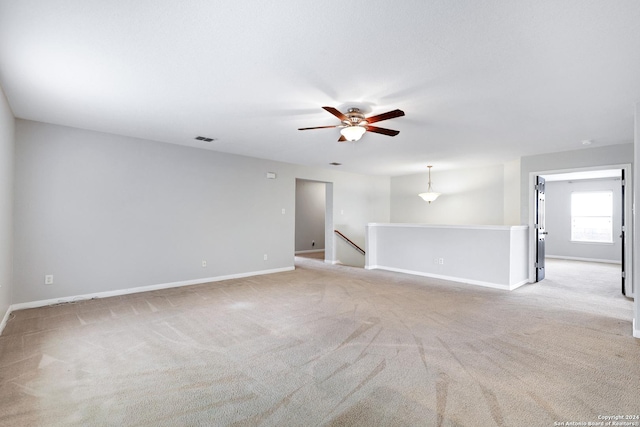 empty room featuring ceiling fan and light colored carpet