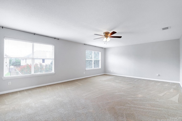 carpeted spare room with ceiling fan and a textured ceiling