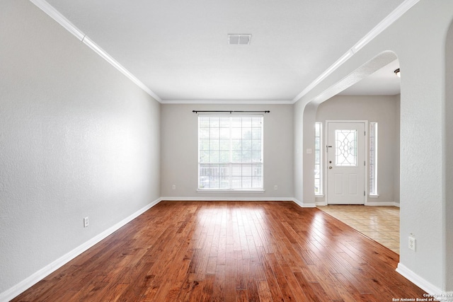 entryway with ornamental molding and light hardwood / wood-style flooring