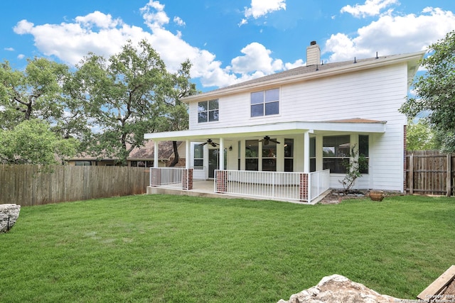 back of house featuring ceiling fan and a lawn