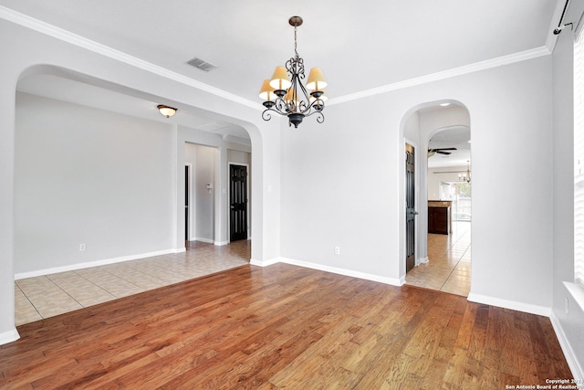 unfurnished room with an inviting chandelier, light hardwood / wood-style flooring, and ornamental molding