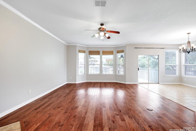 unfurnished living room featuring ceiling fan with notable chandelier, wood-type flooring, and ornamental molding