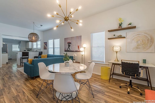 dining area with wood-type flooring and a notable chandelier