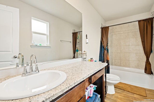 full bathroom with vanity, hardwood / wood-style flooring, toilet, and shower / bath combo