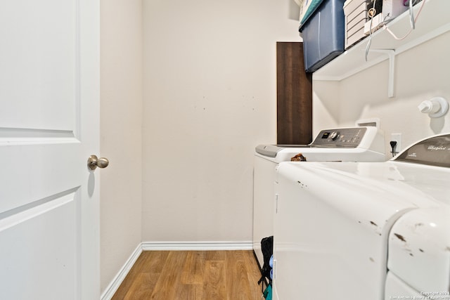 laundry area with separate washer and dryer and wood-type flooring