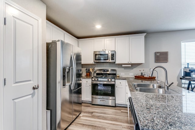 kitchen with white cabinetry, sink, light wood-type flooring, and appliances with stainless steel finishes