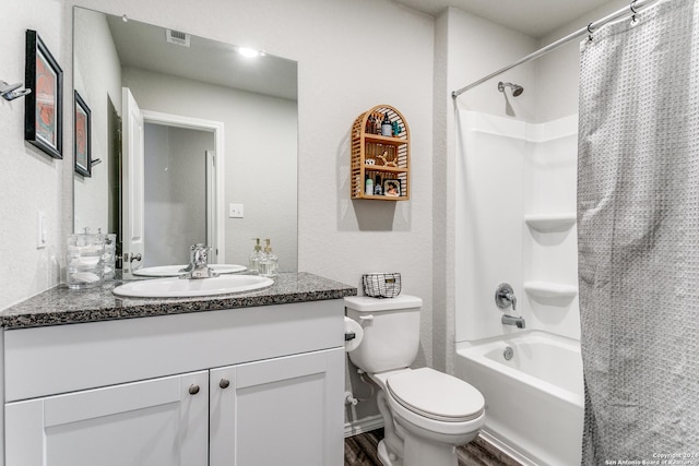 full bathroom with vanity, hardwood / wood-style floors, shower / tub combo, and toilet