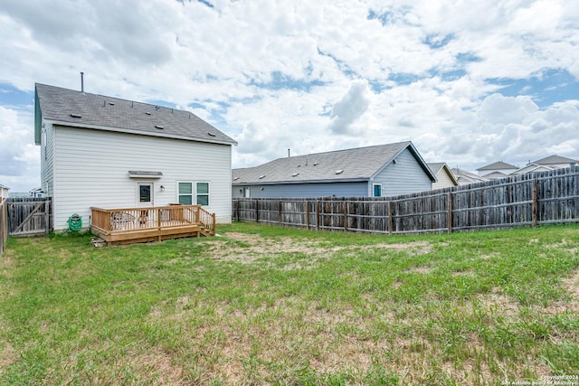 back of property with a yard and a deck