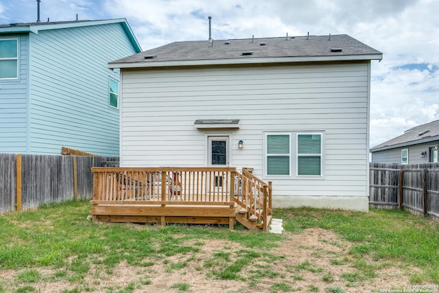 rear view of property featuring a yard and a deck