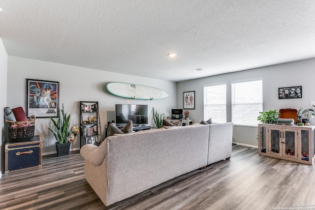 living room with dark hardwood / wood-style flooring and a textured ceiling