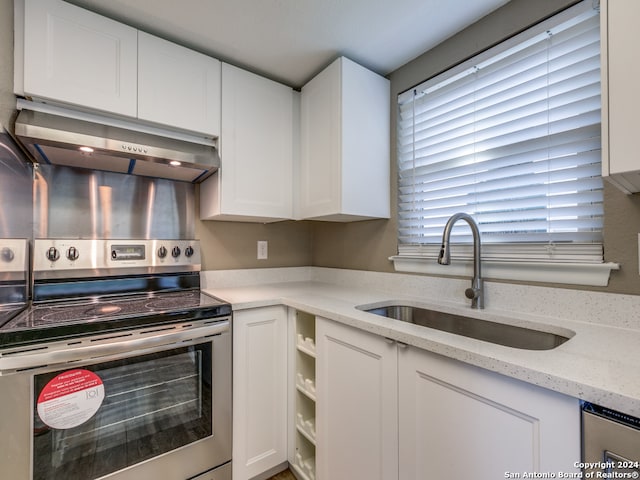 kitchen featuring sink, light stone countertops, white cabinets, and stainless steel range with electric cooktop