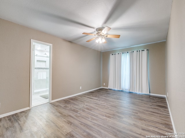 empty room featuring hardwood / wood-style flooring, a textured ceiling, and ceiling fan