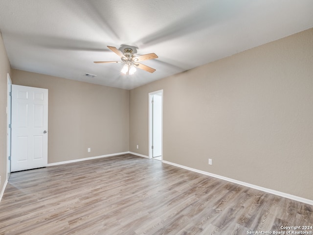 empty room featuring ceiling fan and light hardwood / wood-style flooring