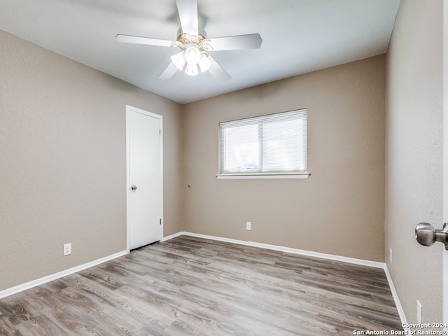 spare room featuring wood-type flooring and ceiling fan