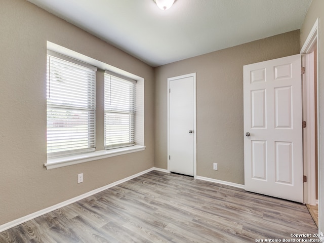 unfurnished bedroom featuring light hardwood / wood-style flooring and a closet