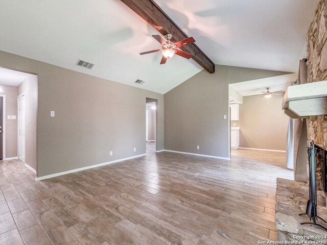 unfurnished living room featuring a fireplace, wood-type flooring, ceiling fan, and vaulted ceiling with beams